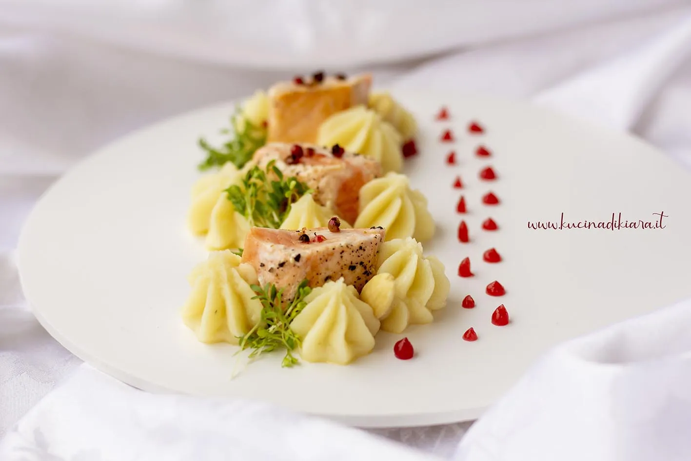Cubetti di salmone con purè di sedano rapa, gel di lampone e crescione